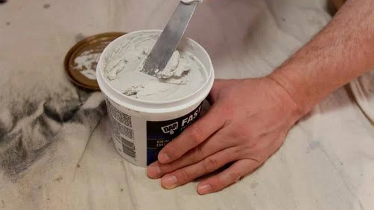 Painter patching and sanding walls during interior painting prep in Seattle home